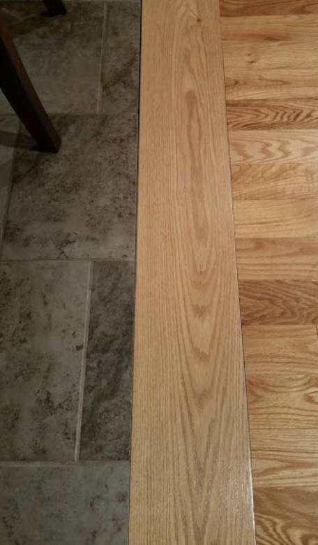 A flush transitions from tile floor to wooden floor