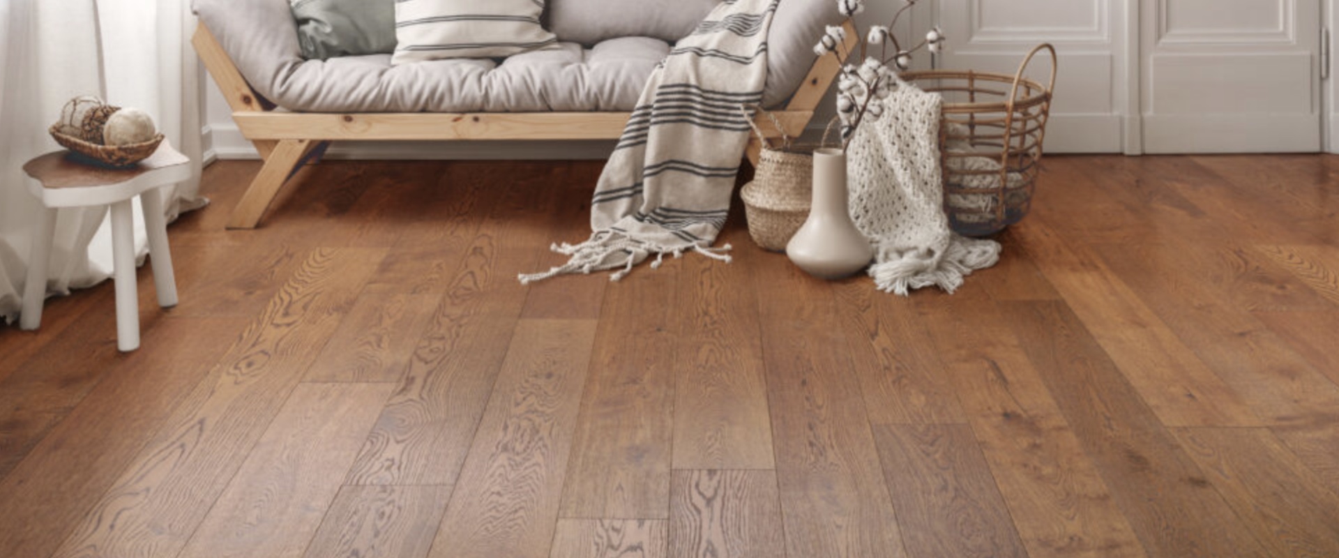 Wide-plank hardwood flooring installed in an Alpharetta living room, warm brown site finish
